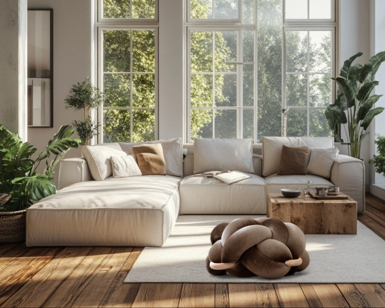 Modern living room with a sectional sofa, coffee table, and large windows.
